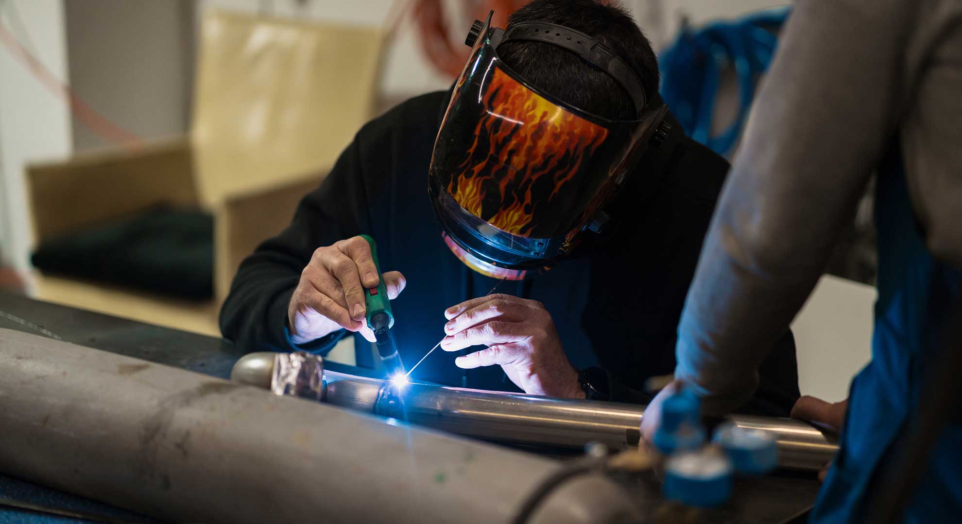 man-working-with-argon-welding-machine-in-a-garage-